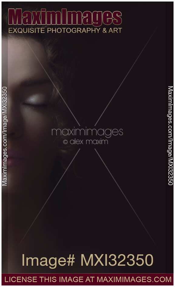 Beautiful tranquil woman face with closed eyes half hidden by shadows dreamy portrait
