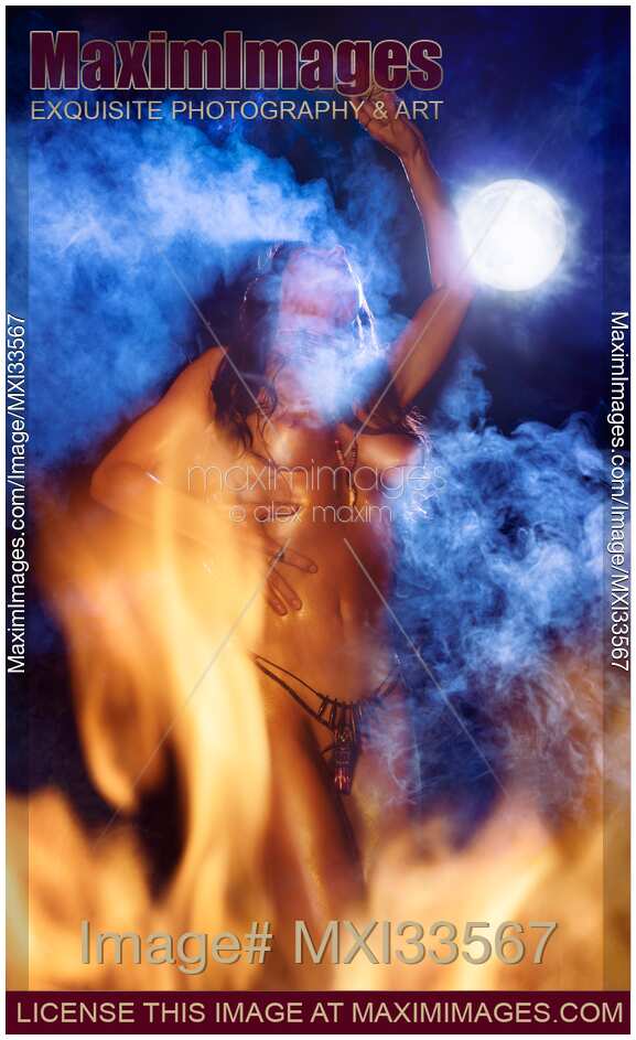 Beautiful tribal aboriginal woman dancing naked at night in full moon surrounded by smoke and fire flames