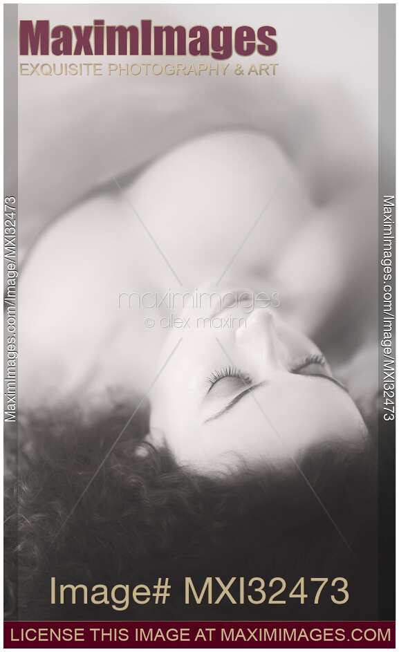Beautiful woman face with delicate features lying with closed eyes in soft black and white colors