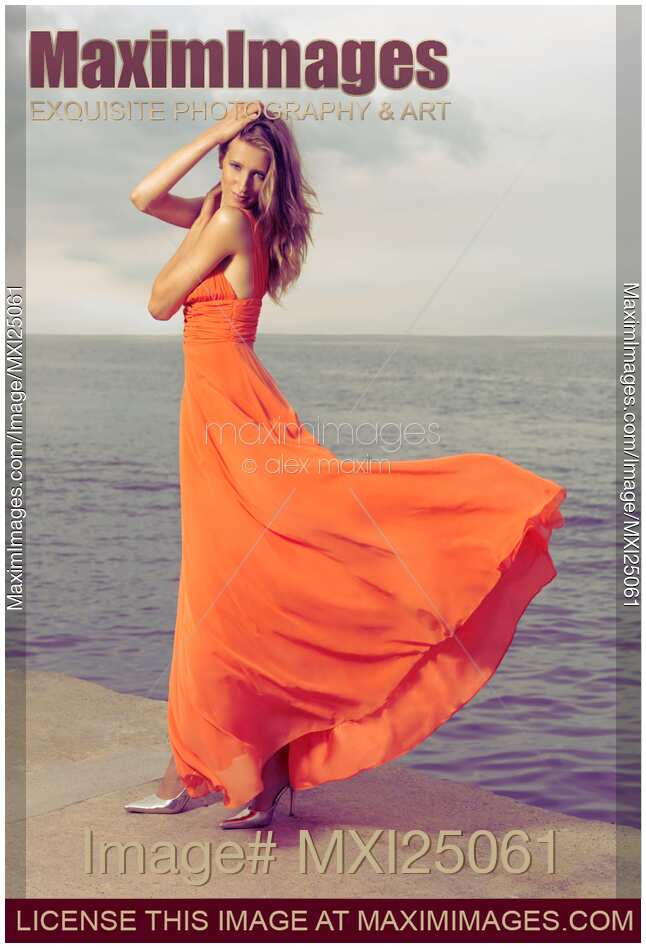 Beautiful Woman in Orange dress on Sea Shore