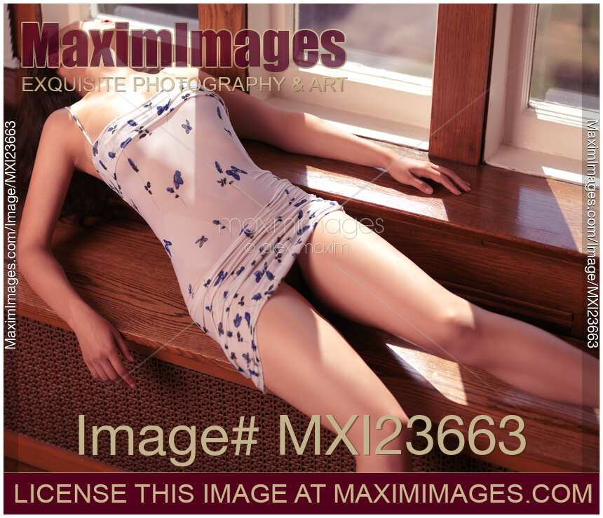 Beautiful Woman in Short Dress Lying on Window Sill