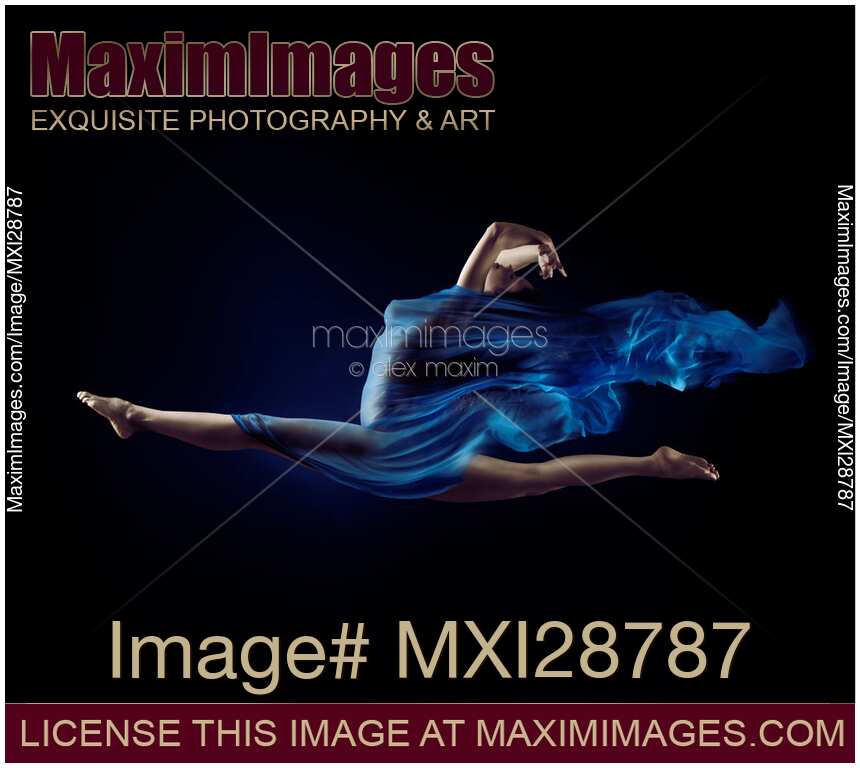 Beautiful woman making splits in the air with flowing blue cloth wrapped around her body
