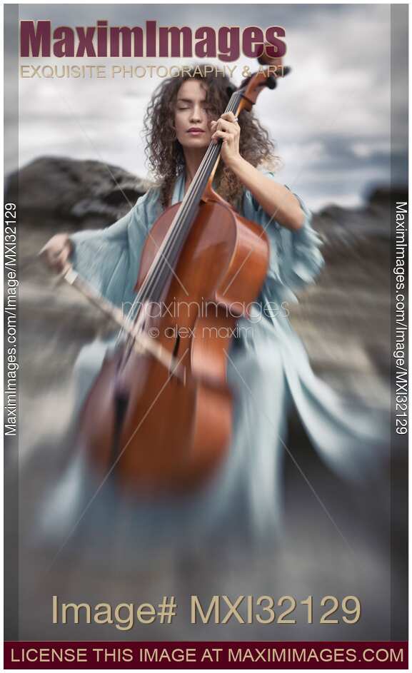 Beautiful woman thoughtfully playing cello in the nature with dreamy tranquil expression