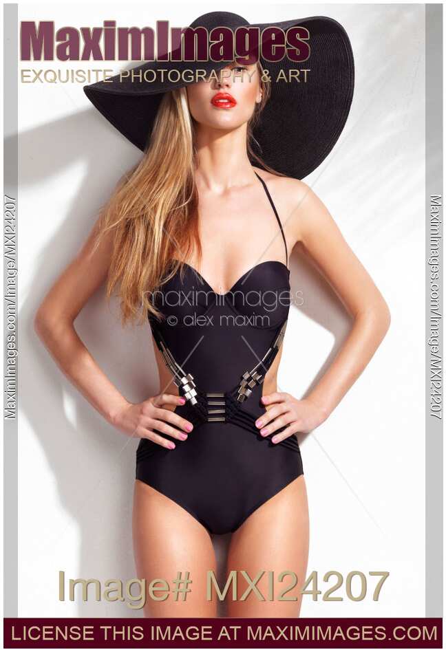 Beautiful woman wearing a one-piece swimsuit and a sun hat