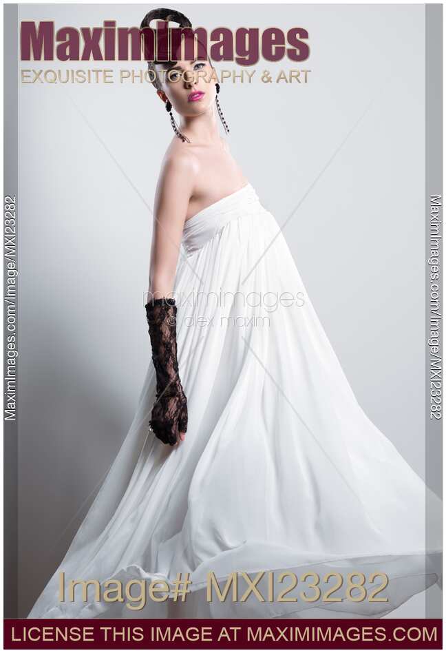 Beautiful Woman with a Creative Hairstyle Wearing a Long White Dress