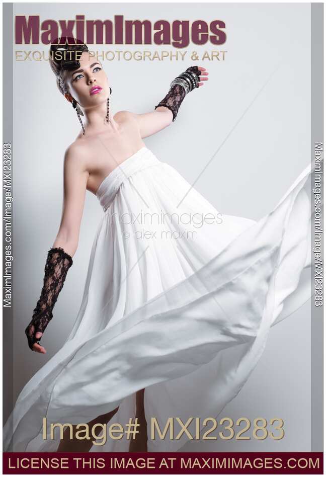Beautiful Woman with a Creative Hairstyle Wearing a Long White Dress