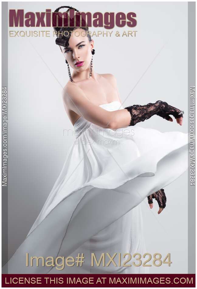 Beautiful Woman with a Creative Hairstyle Wearing a Long White Dress