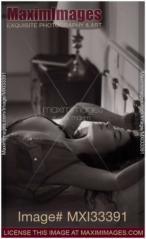 Beautiful woman with bared chest making love in bed arching her chest Sensual black and white portrait