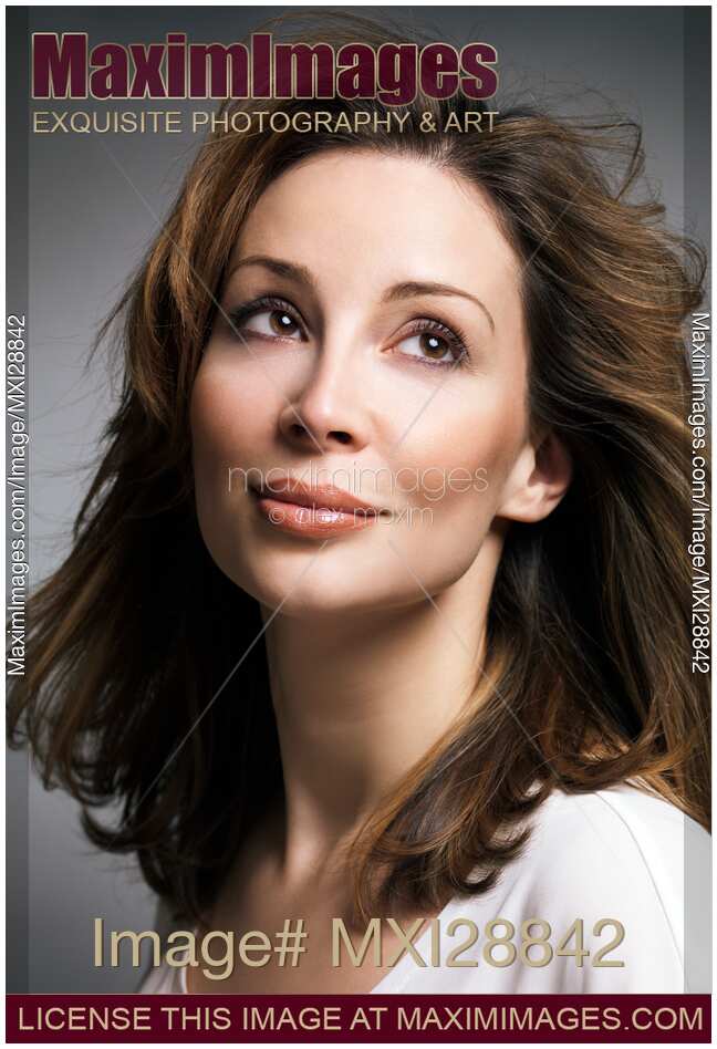 Beautiful woman with brown hair and daydreaming expression
