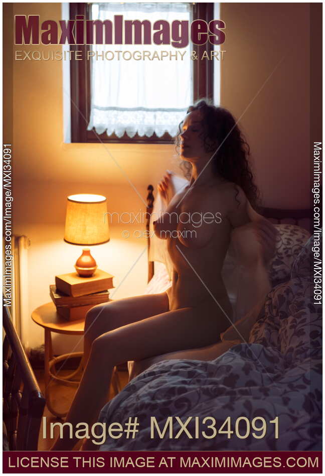 Beautiful woman with sensual nude body getting up naked from a bed in the morning dressing up