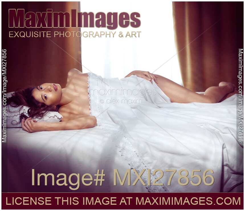 Beautiful young asian woman lting naked in bed covered with white sheets