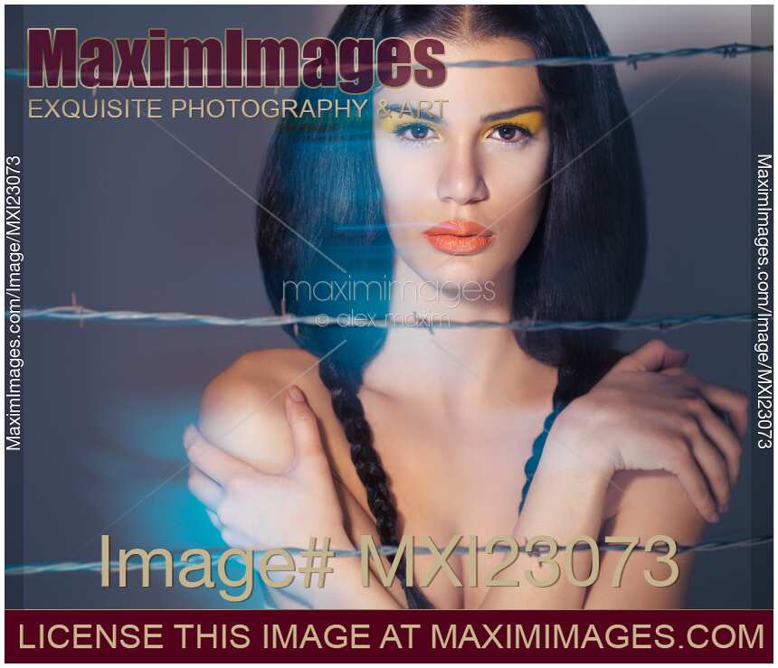 Beautiful Young Woman Behind Barbed Wire