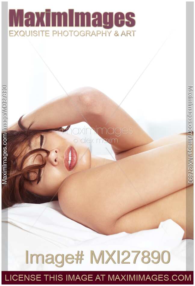 Beautiful young woman lying topless in bed clsoeup of face