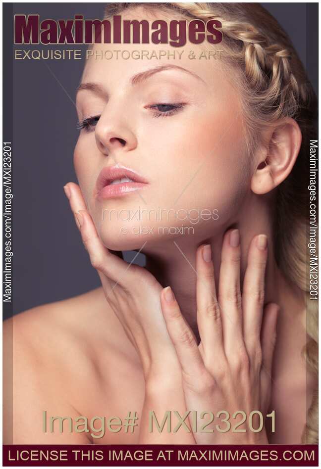 Beautiful young woman touching her face with natural light makeup