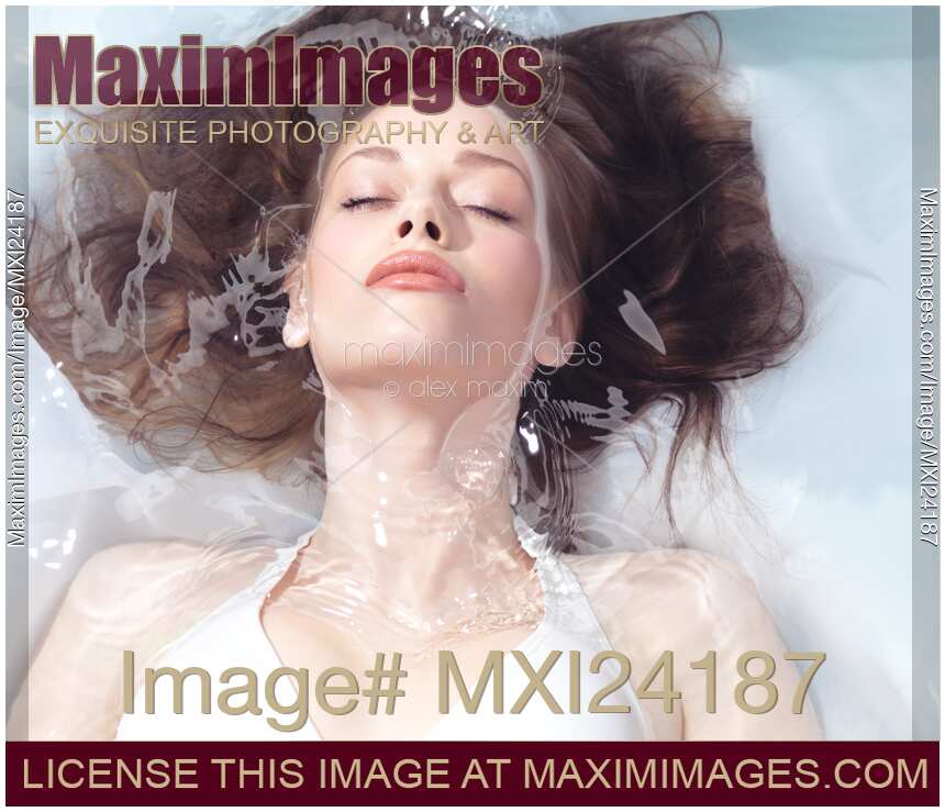 Beautiful young woman with fresh face lying relaxed in water
