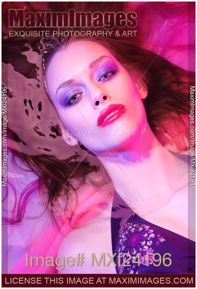 Beauty face portrait of woman lying in water with makeup in vivid pink colors