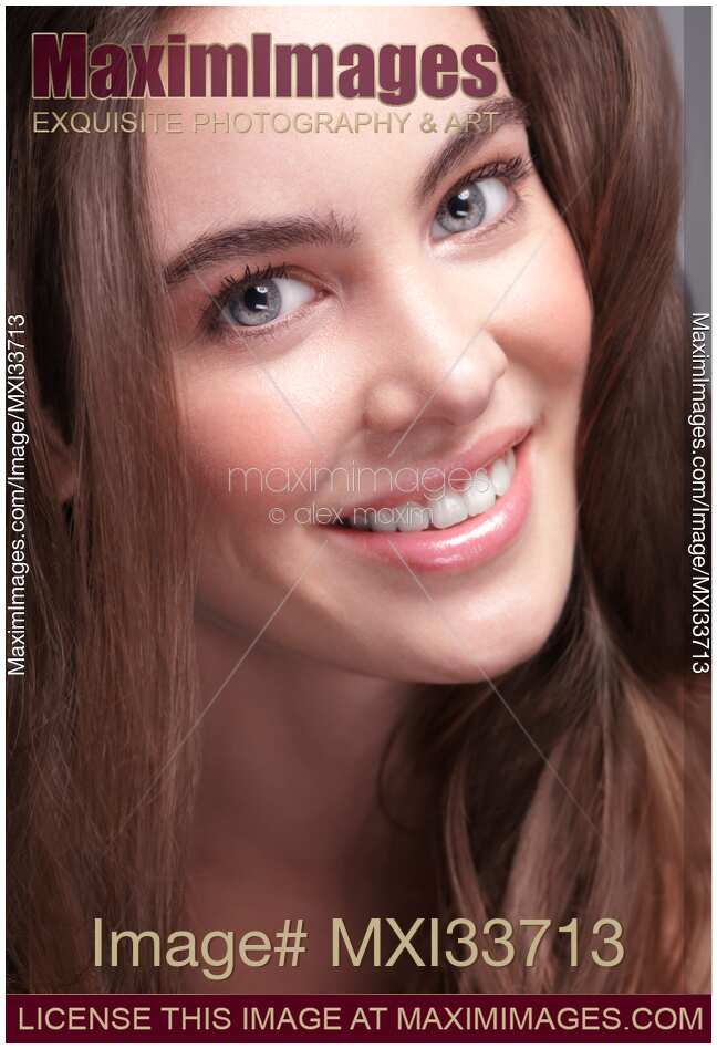 Beauty portrait of a smiling young woman closeup of face with big grey eyes and natural healthy soft look