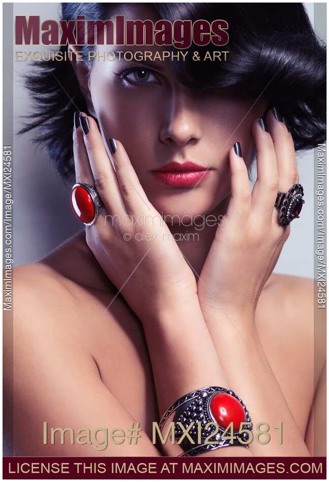 Beauty portrait of a woman wearing jewelry with red stones