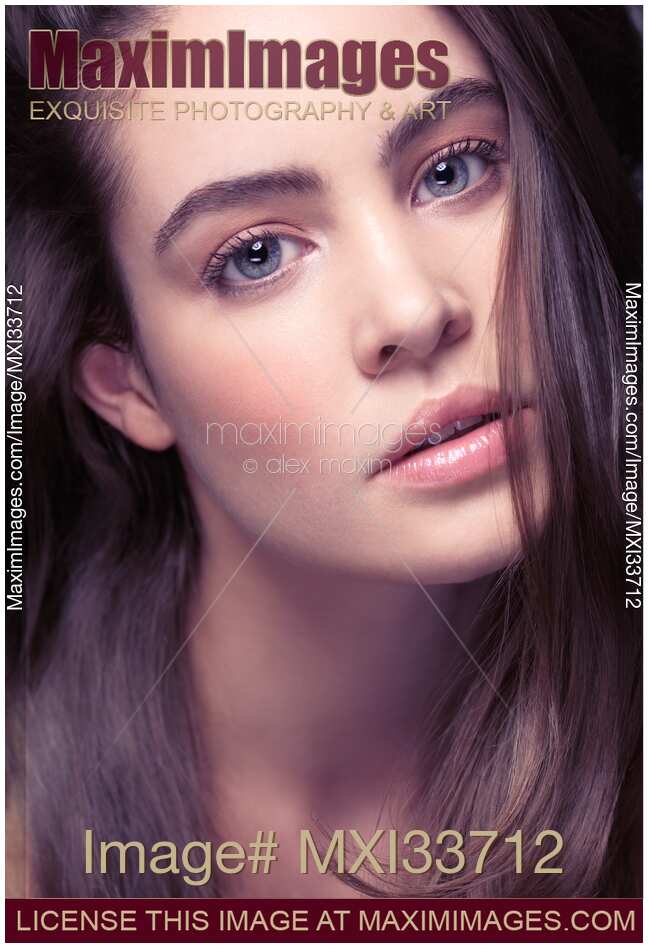 Beauty portrait of a young woman face with beautiful large grey eyes and long brown hair