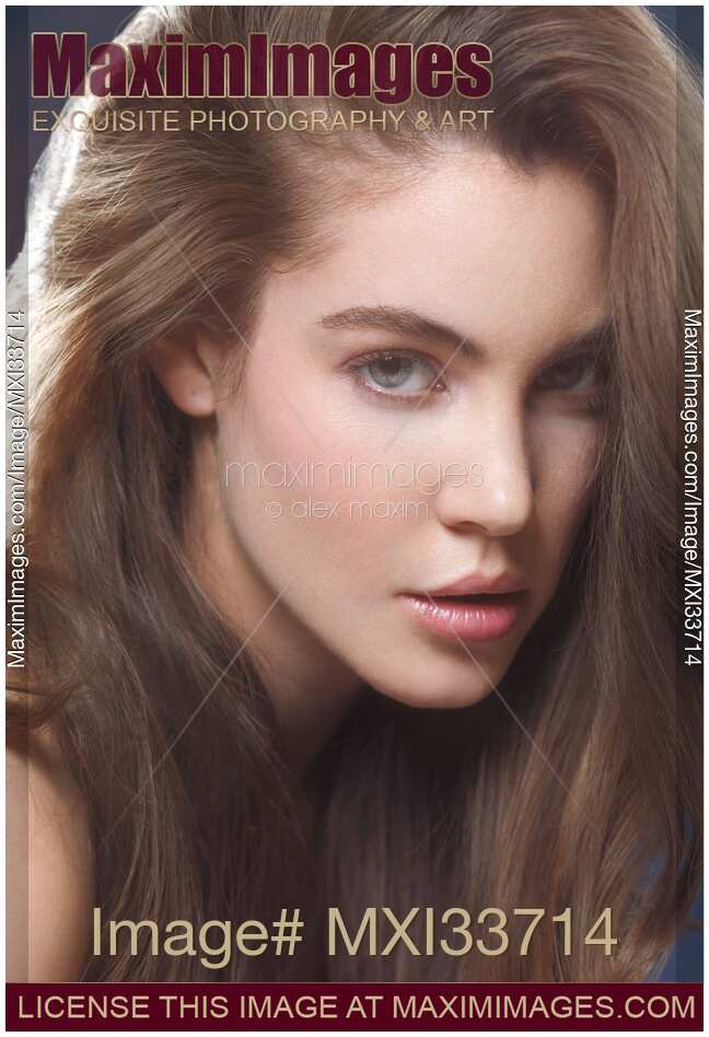 Beauty portrait of a young woman face with sensual look, grey eyes and long brown hair