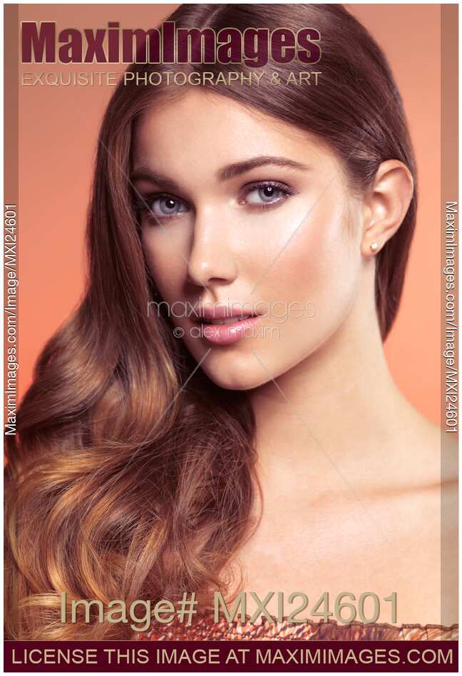 Beauty portrait of a young woman face with wavy brown hair neatly brushed to one side