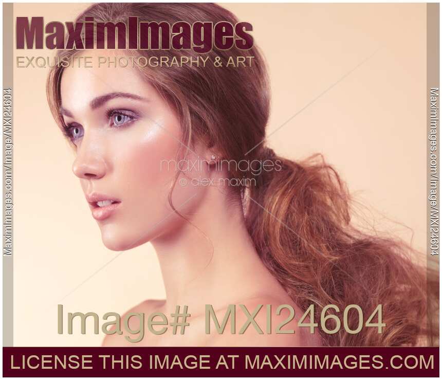 Beauty portrait of a young woman with long red hair in a ponytail