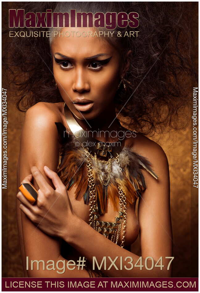 Beauty portrait of exotic native woman with tribal feather necklace over naked bronze skin and bare breasts