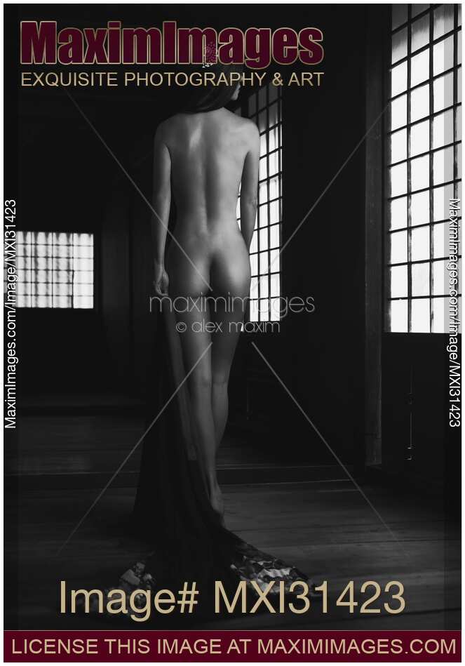 Black and white fine art nude Japanese woman undressed in dark house her nude back glowing in soft light of shoji screens