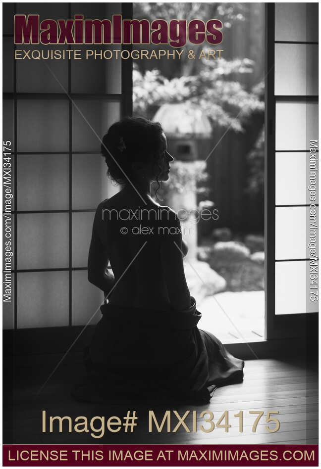 Black and white silhouette of a beautiful woman with naked back sitting by an open door of a Japanese house with Zen garden