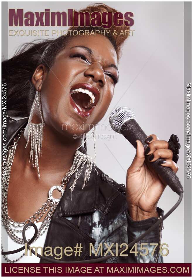 Black woman singing in microphone
