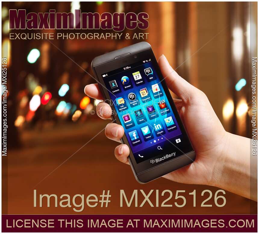 Blackberry Z10 smartphone in hand on street at night