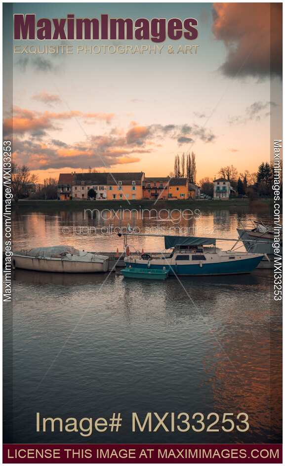 Boats in sunset scenery at Tournus town on the Saône River in France