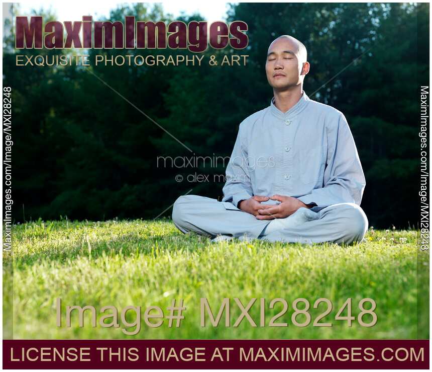 Buddhist monk meditating during sunrise