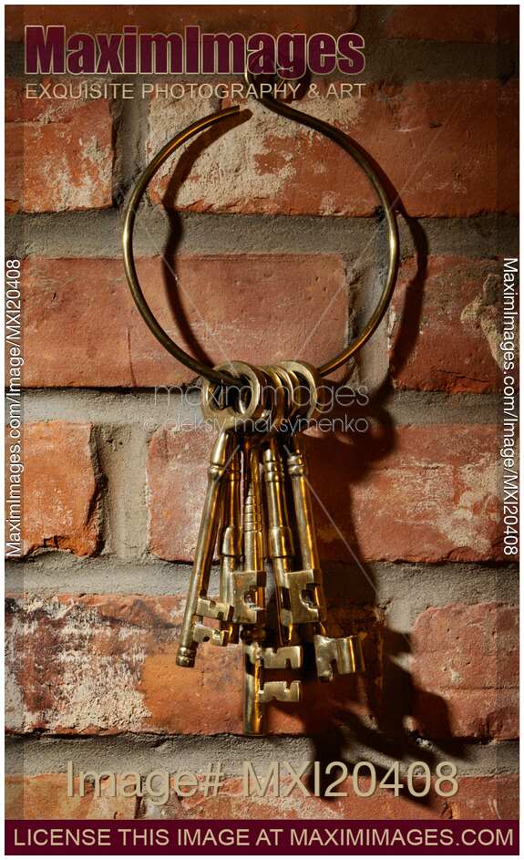 Bunch of antique keys hanging on brick wall