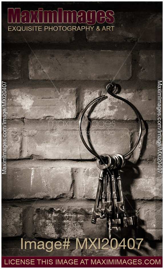 Bunch of antique keys on brick wall background black and white