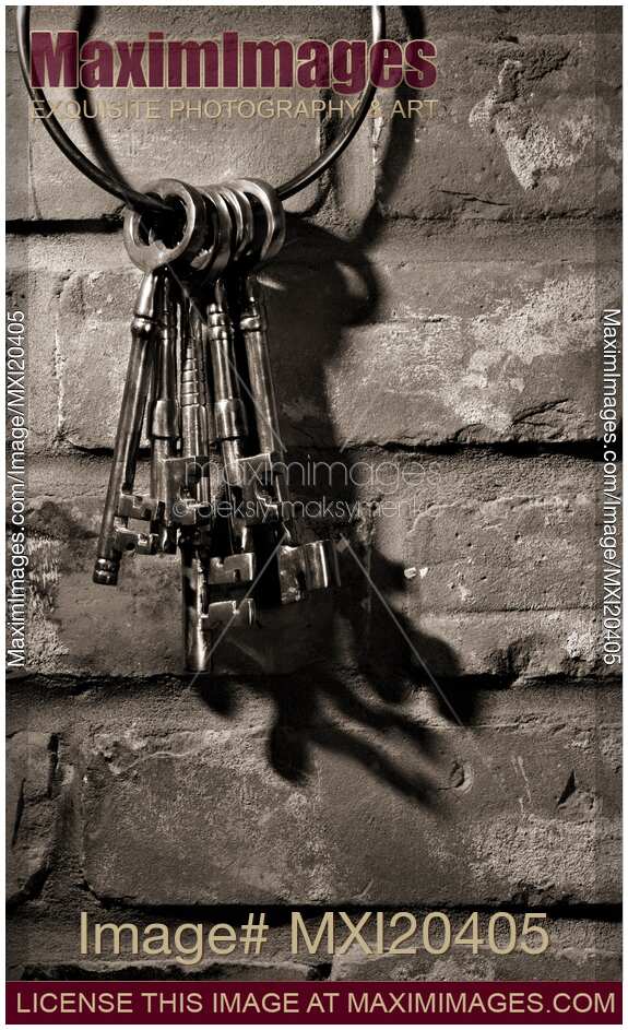 Bunch of antique keys on brick wall black and white