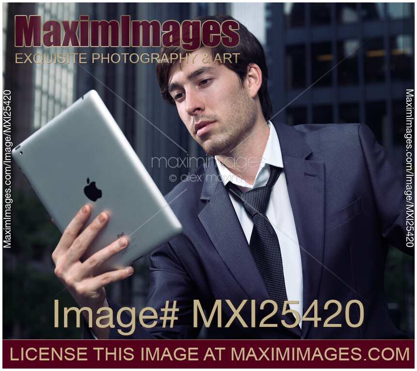 Businessman using Apple iPad in city downtown