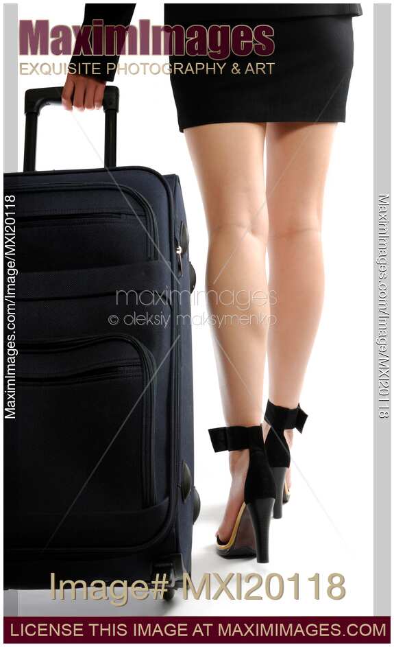 Businesswoman walking with suitcase closeup of legs