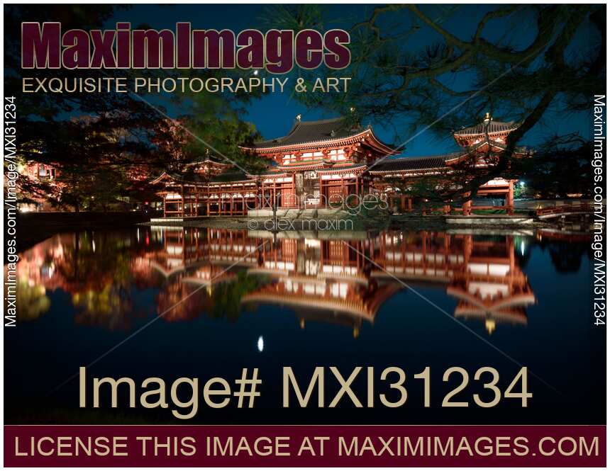 Byodoin temple Phoenix Hall illuminated with lights in nighttime scenery reflecting in calm water of garden pond