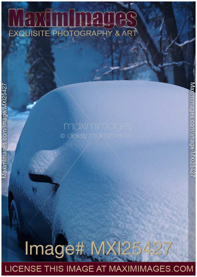 Car in snow storm covered with snow in winter