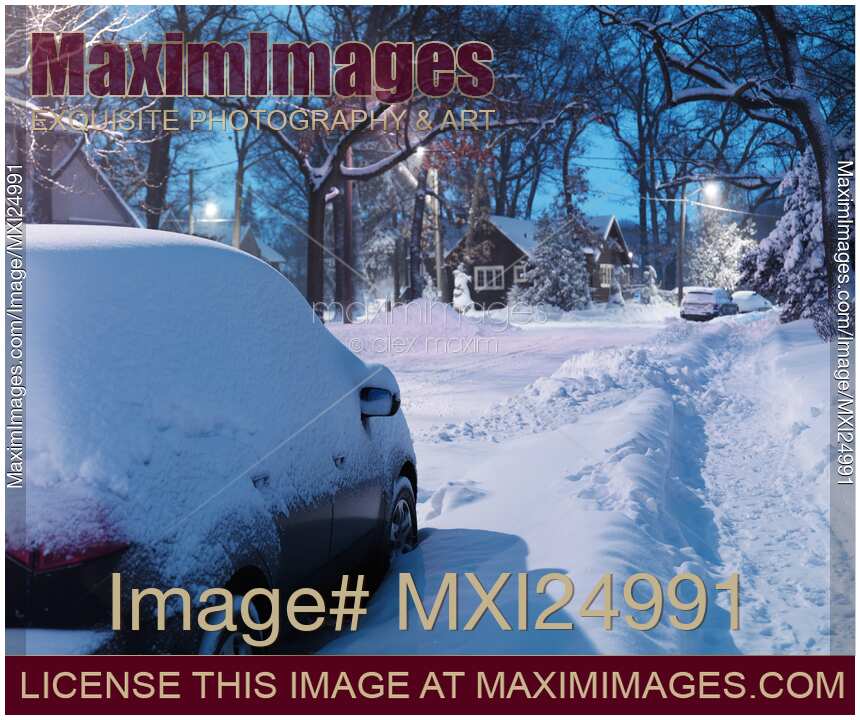 Cars covered with snow on city street in winter