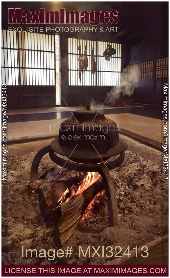 Cast iron kettle Kama boiling on fire in a sunken hearth Irori in a floor of a Japanese house