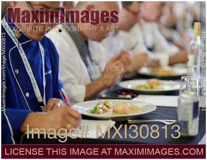 Chef competition judge making notes on a gourmet competition meal at BC Seafood Festival