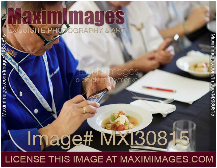 Chefs competition judge making pictures of a gourmet meal at BC Seafood Festival