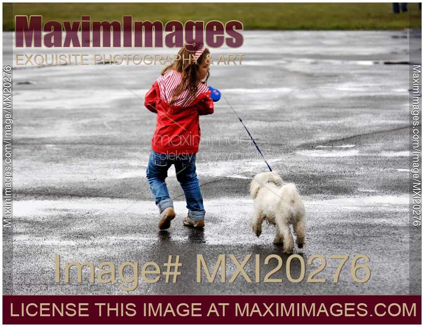 Child playing with dog in the rain