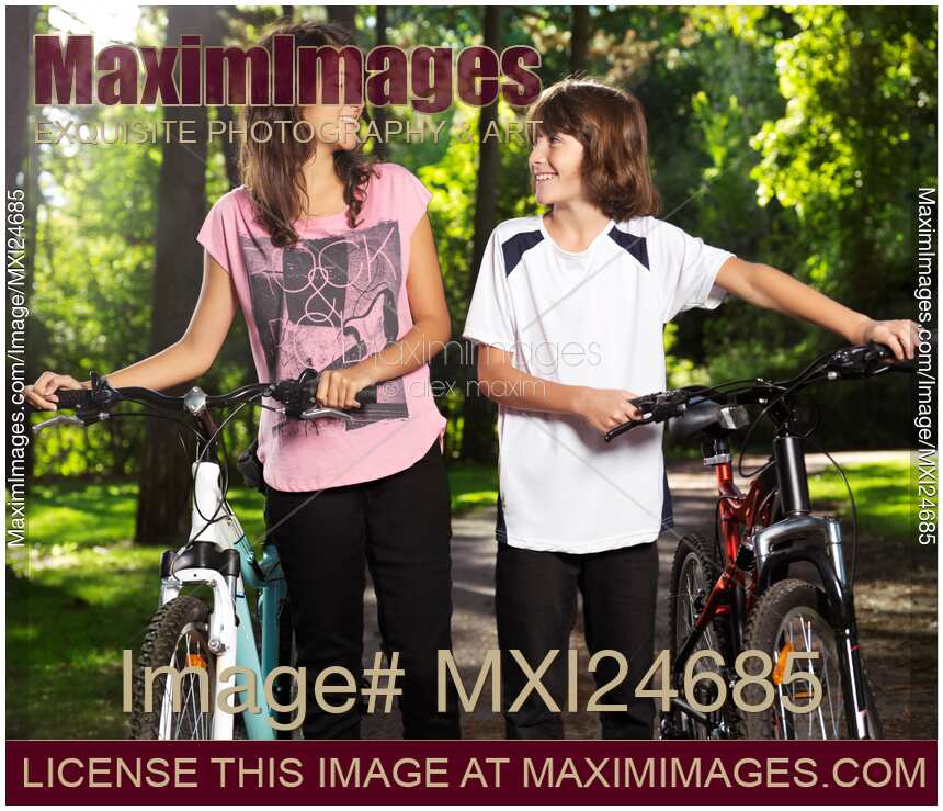 Children with bicycles wallking in park