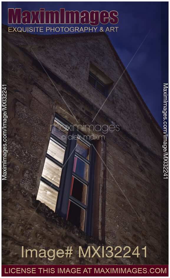 Closed lit from inside window of an old house at night in South of France artistic domestic concept