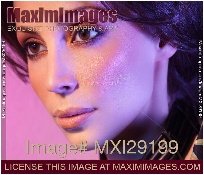 Closeup beauty portrait of woman face in colored purple light