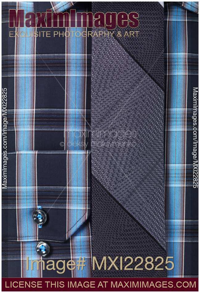 Closeup of a blue tartan shirt with a slim tie
