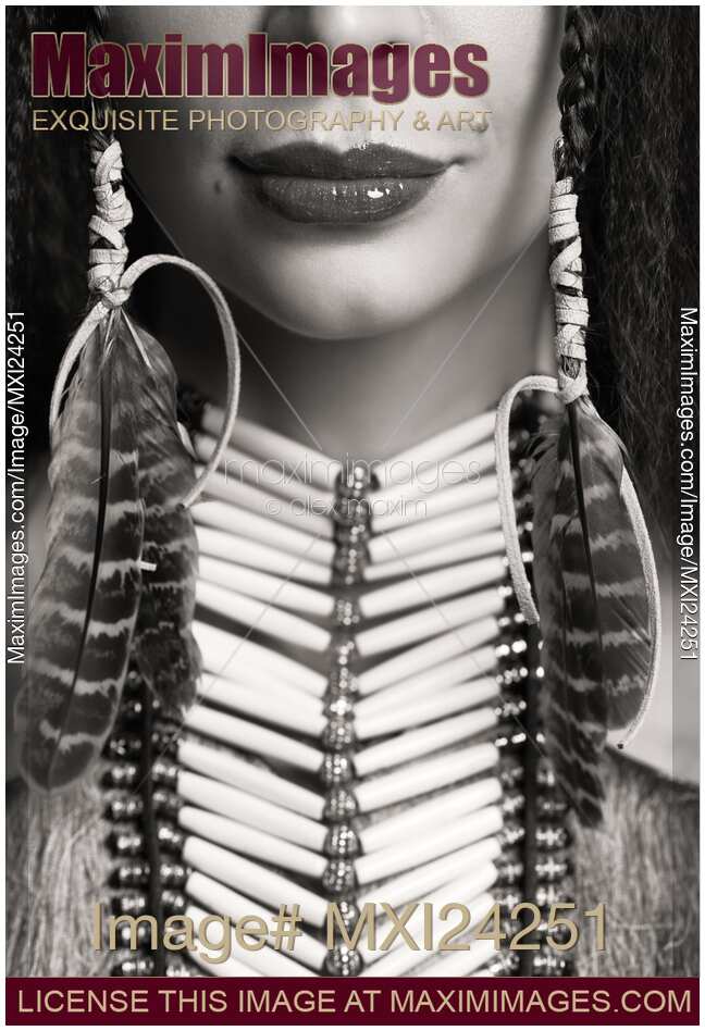 Closeup of lips of a woman wearing aboriginal necklace and feathers